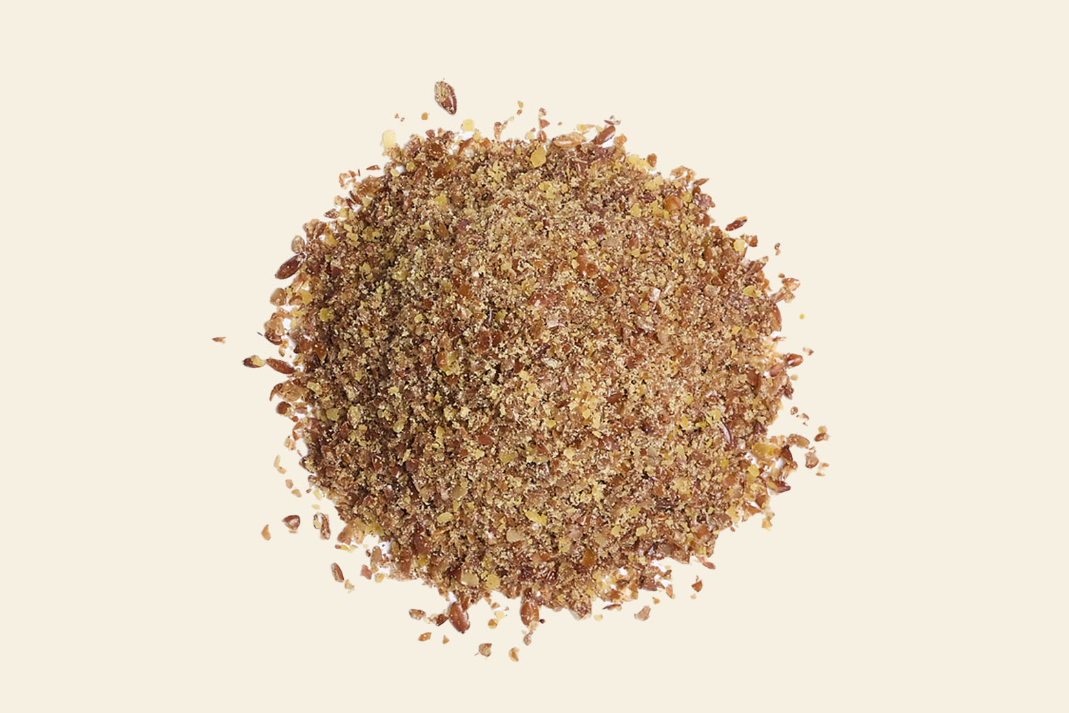 A pile of ground flaxseeds rests on a light background. These seeds showcase a brown and golden hue with a coarse texture, reflecting their natural beauty.