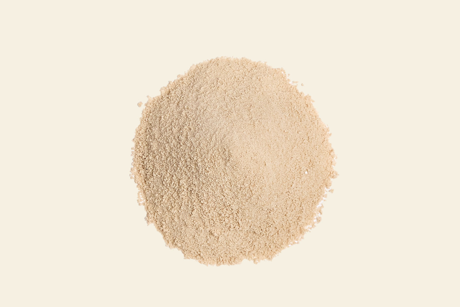 A small mound of beige, granulated yeast on a light, neutral background. The texture appears dry and fine, typically used in baking and cooking.