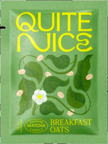 A green packet of Quite Nice Breakfast Oats adorned with leaves, oats, and a flower proudly displays text reading The Gut Friendlyest and Energizing Matcha & Vanilla. Packed with real food ingredients, it supports gut health while invigorating your mornings.